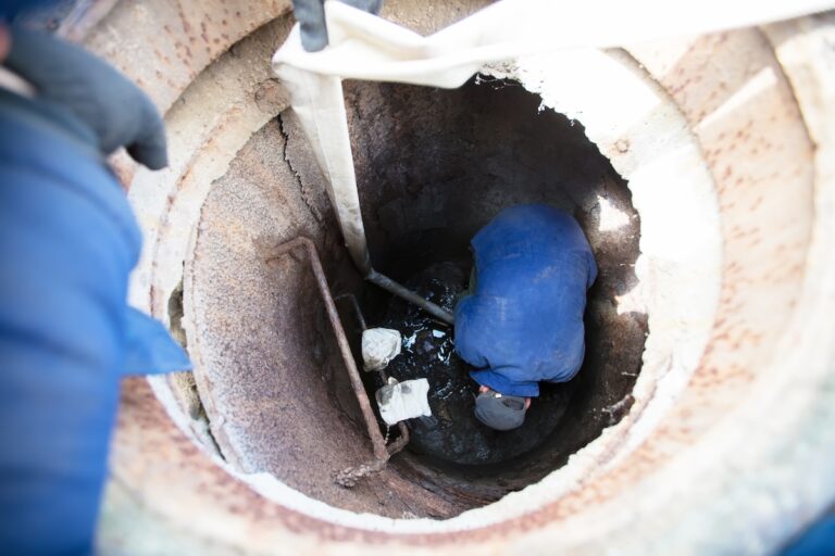 Worker cleans the sewer hatch.