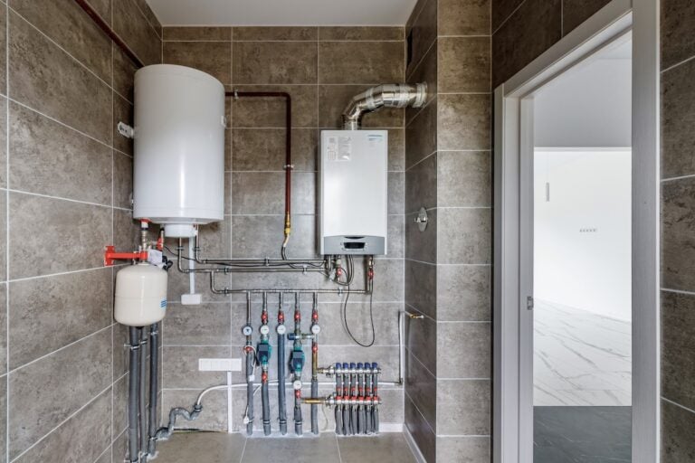 Copper valves, stainless ball valves, detectors of water pressure and plastic pipes of central heating system and water pipes with thermal insulation in the boiler room in apartment during under