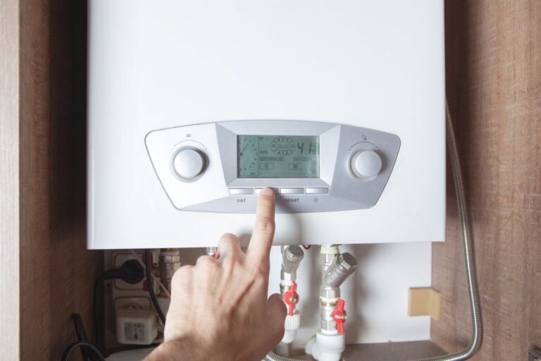 worker set up central gas heating boiler at home