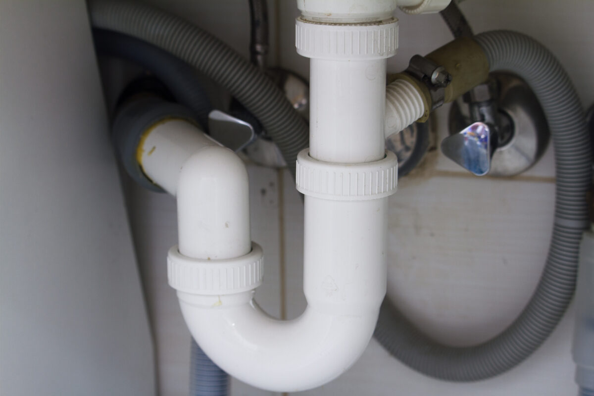 how does a sewer system work Trap pvc grey under kitchen stainless steel sink with a flexible tube over flow connect in white wall ceramic tile